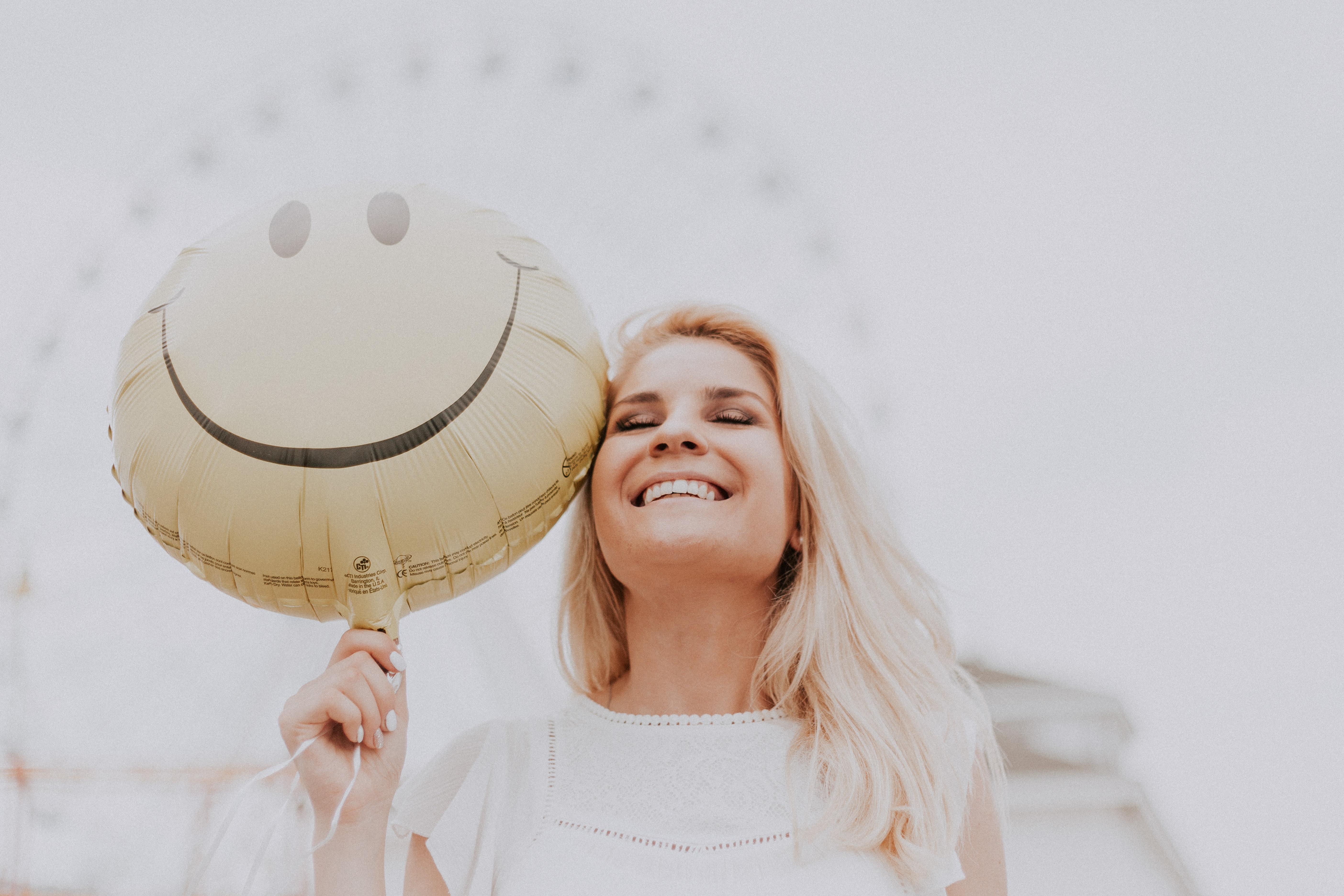 woman-holding-a-smiley-balloon-1236678-2