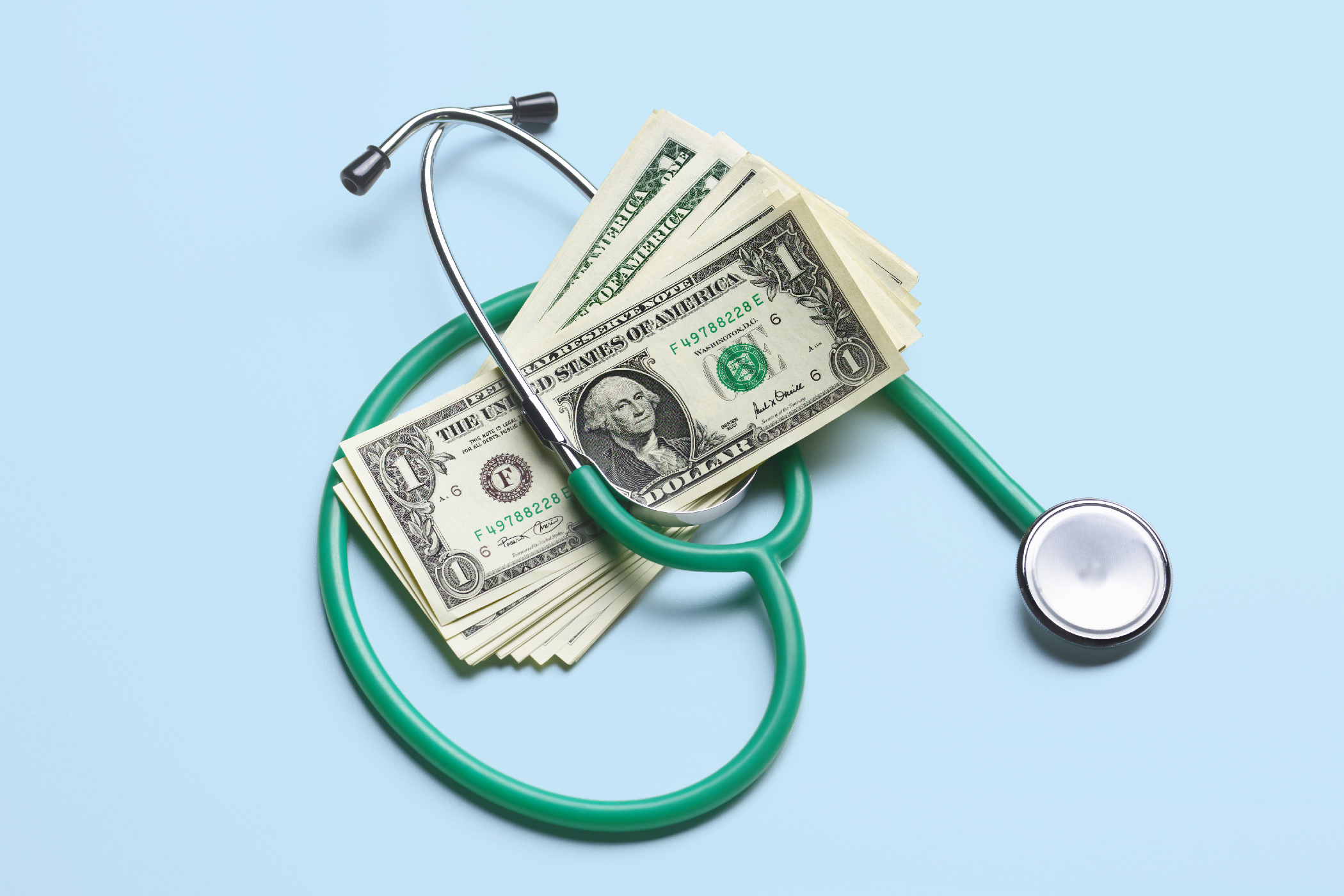Money in green stethoscope teaching employees about financial wellbeing and their HSA 