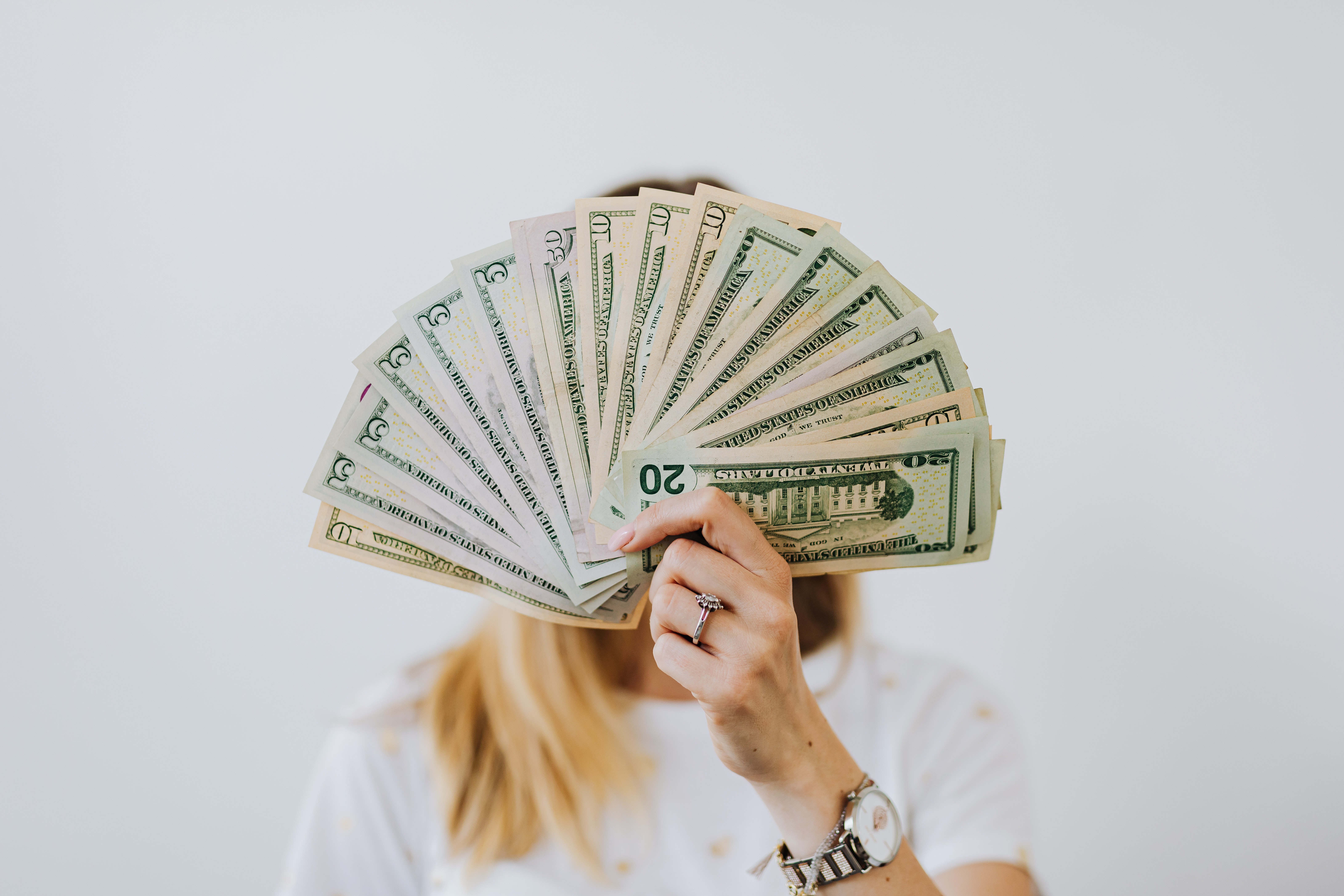 Woman holding 2021 money showing her financial wellbeing with LearnLux