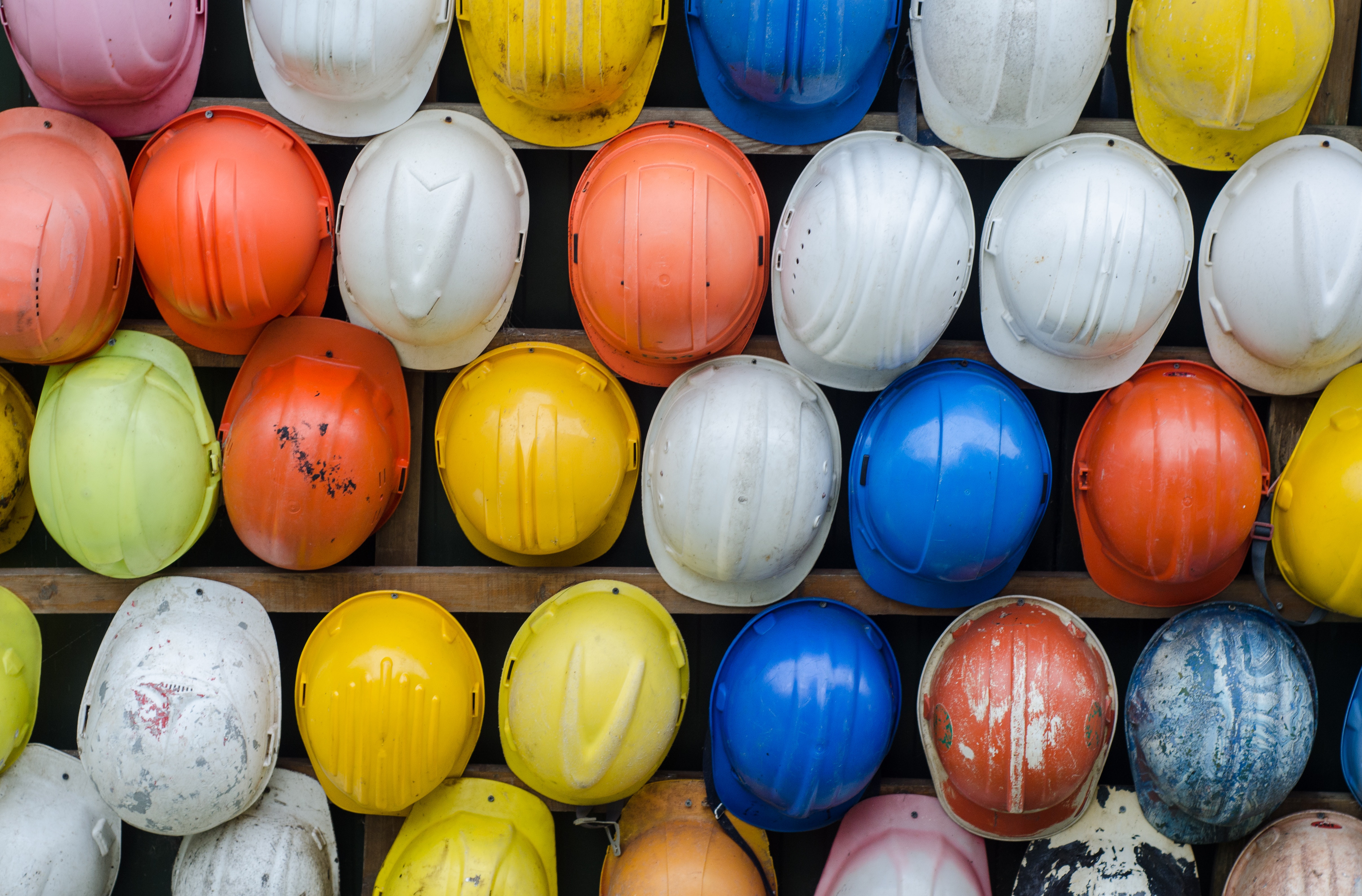 A photo of colorful hardhats for construction and manufacturing companies financial wellbeing program guide